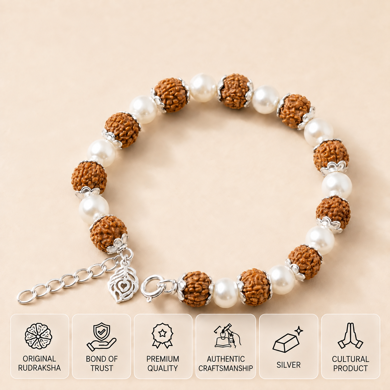 Rudraksha bead bracelet with silver links, clasp and feather charm on cream satin.
