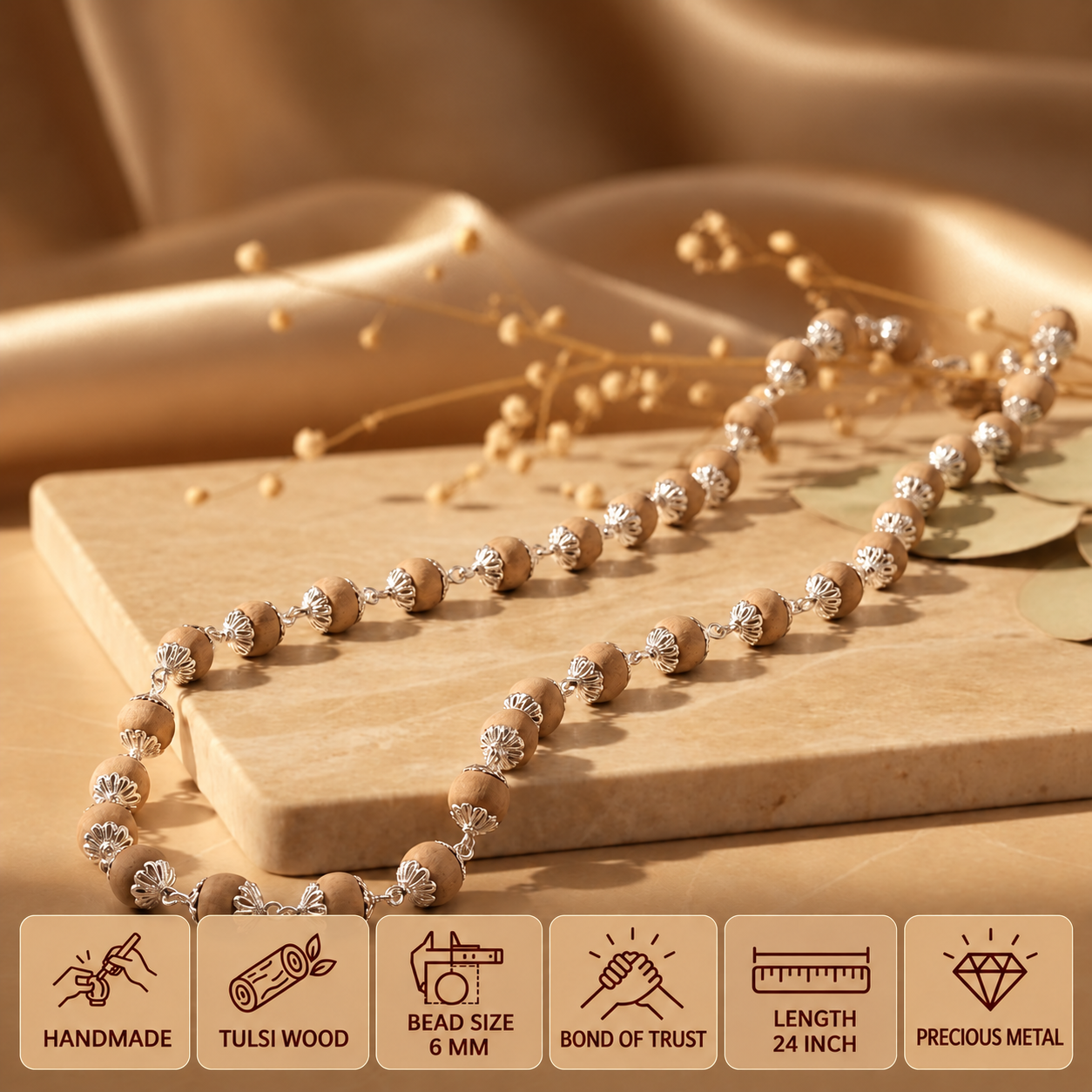 Silver Tulsi mala displayed on a beige stone platform, with feature cards showing 6 mm bead size and 24 inch length.