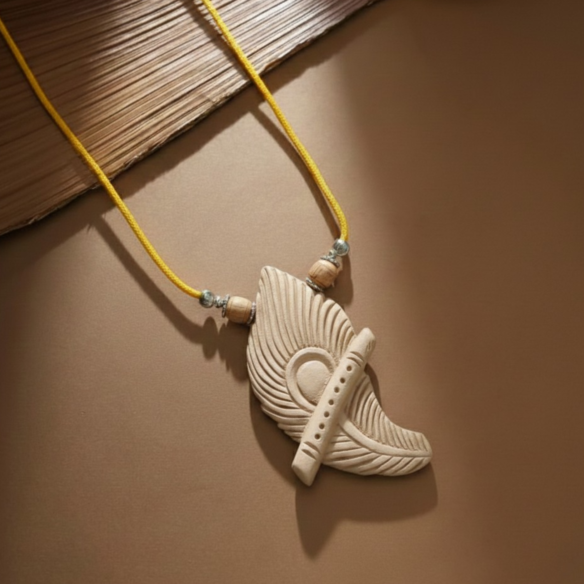 Person wearing a silver pendant featuring a flute and peacock feather carved on Tulsi wood