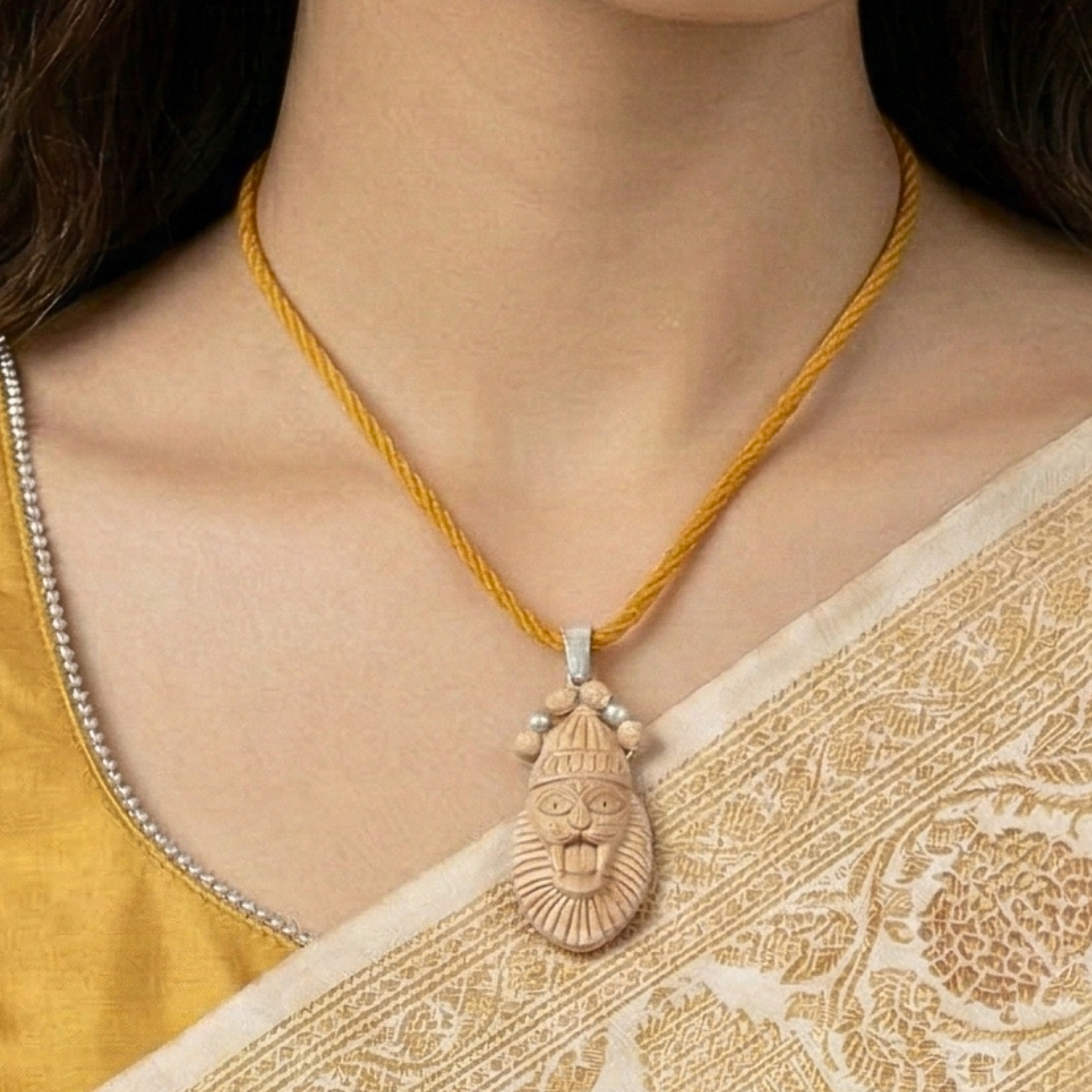 Person wearing a silver pendant featuring a handcrafted Narasimha avatar carved on Tulsi wood