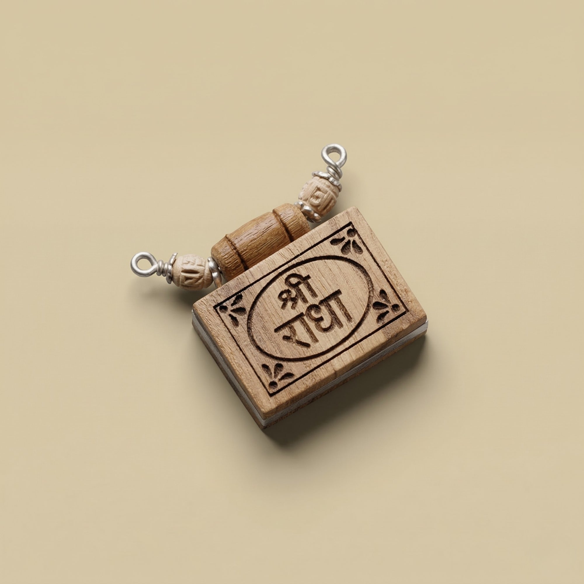 Close up flat lay of a silver pendant featuring authentic Tulsi wood inscribed with the sacred Shri Radha name