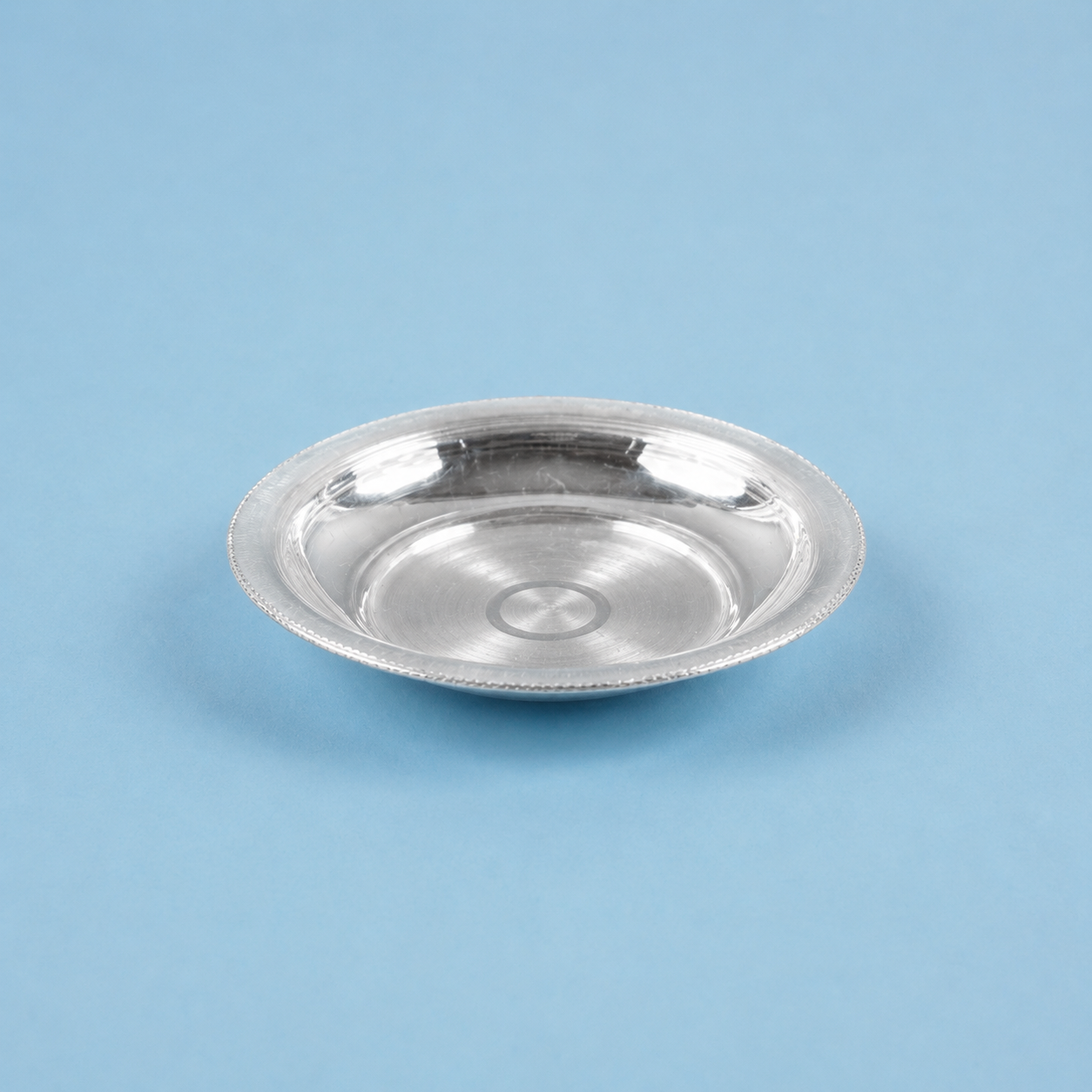 Close-up detail view of handcrafted pure silver utensil plate for deities