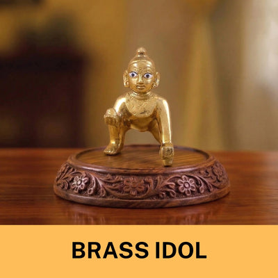 A small, shining brass idol of a kneeling figure with blue eyes.