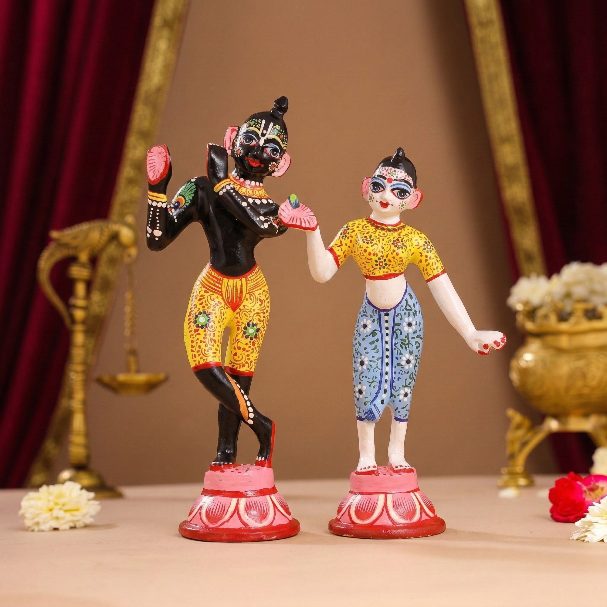 Hand-painted Shringar standing Radha Krishna idol of Yugal Jodi displayed on a temple altar with diyas