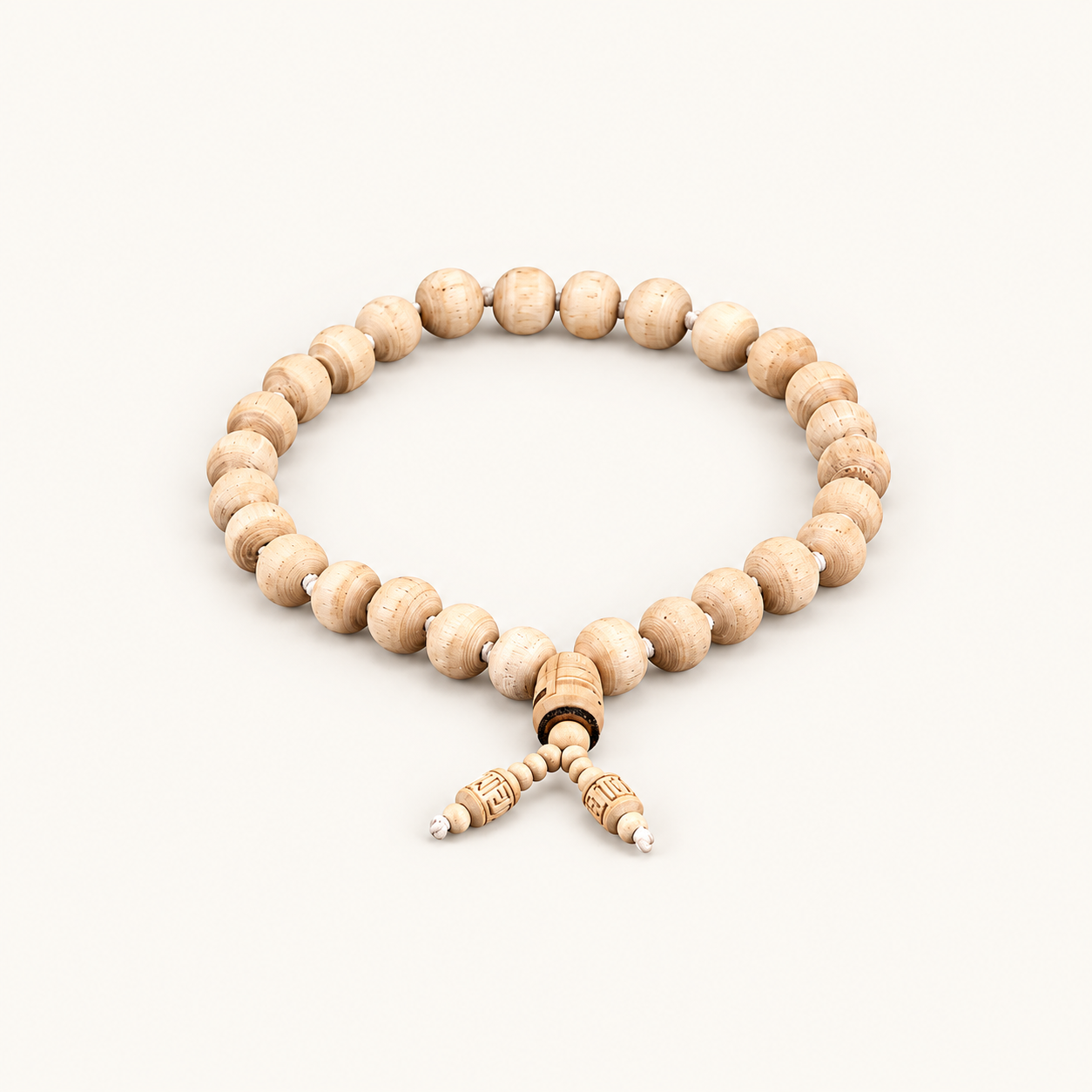 Tulsi bead mala with a carved central bead and two dangling bead ends on an off-white background.