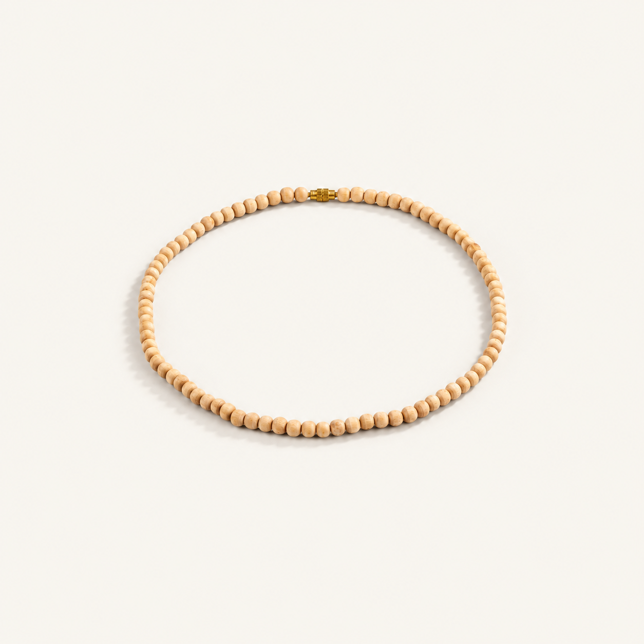 Light brown Tulsi bead mala arranged in a circle with a gold-colored screw clasp on an off-white background.