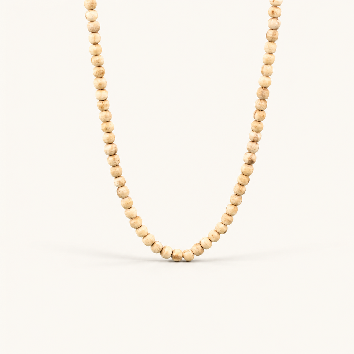 Light brown Tulsi bead mala displayed against a clean off-white background.