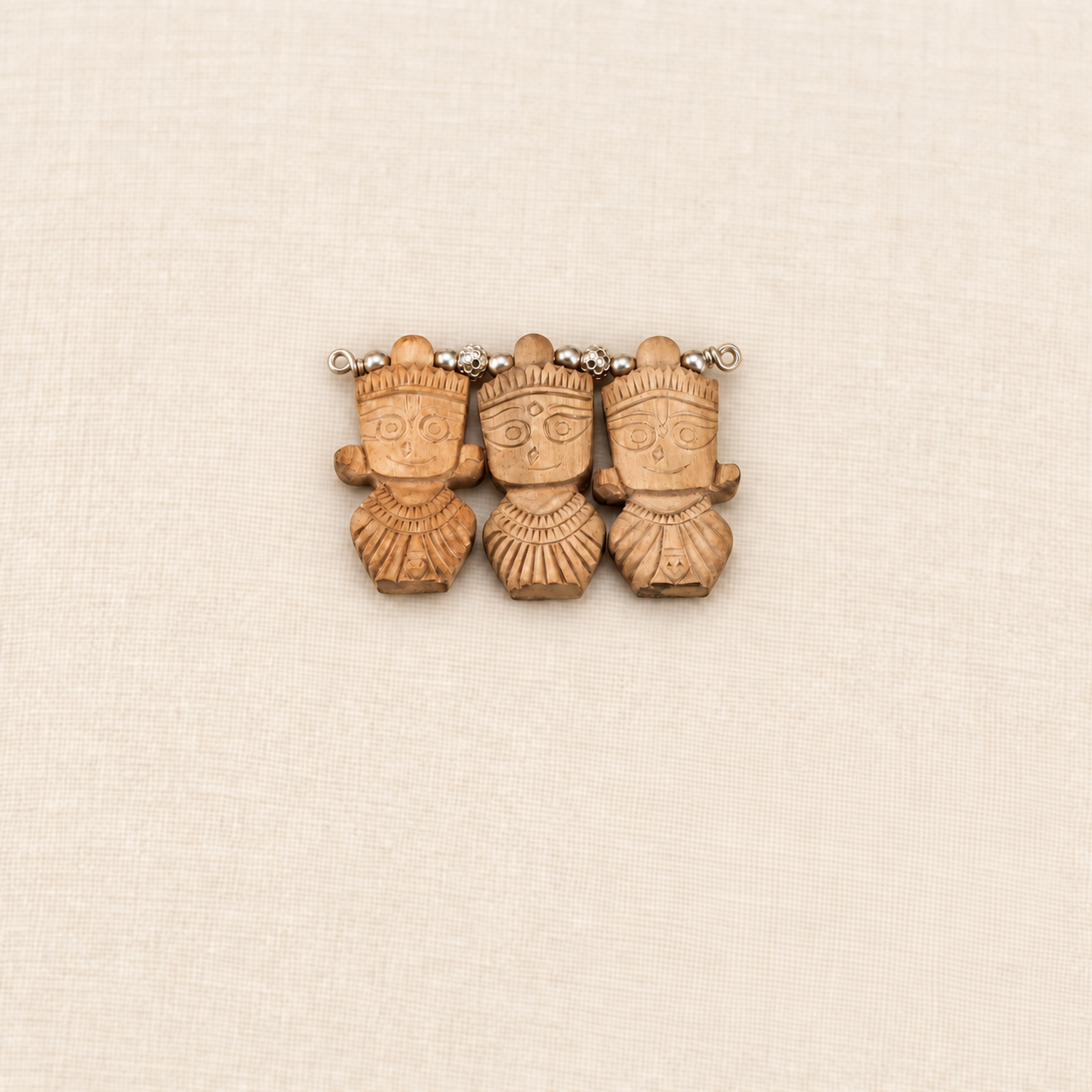 Tulsi wood pendant featuring carved Jagannath, Balabhadra and Subhadra figures with silver beads.