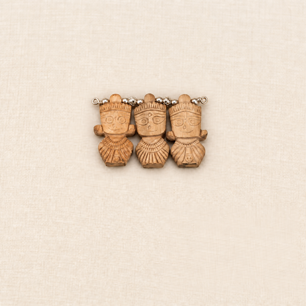 Tulsi wood pendant featuring carved Jagannath, Balabhadra and Subhadra figures with silver beads.