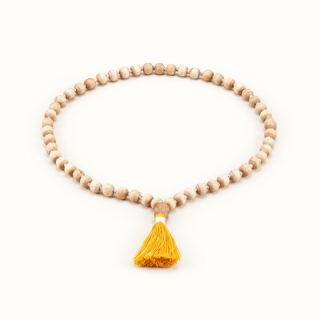 Light wooden Tulsi japa mala arranged in an oval with a yellow tassel on an off-white background.