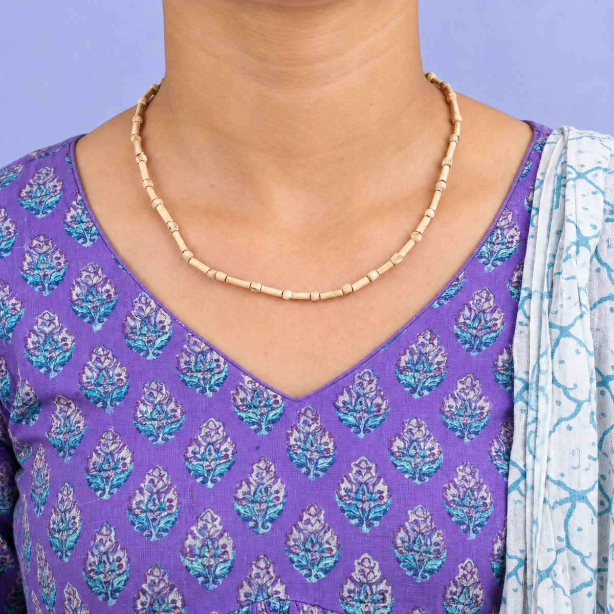 Tulsi kanthi mala with slender cylindrical wooden beads and small spacers worn with a purple printed kurta.