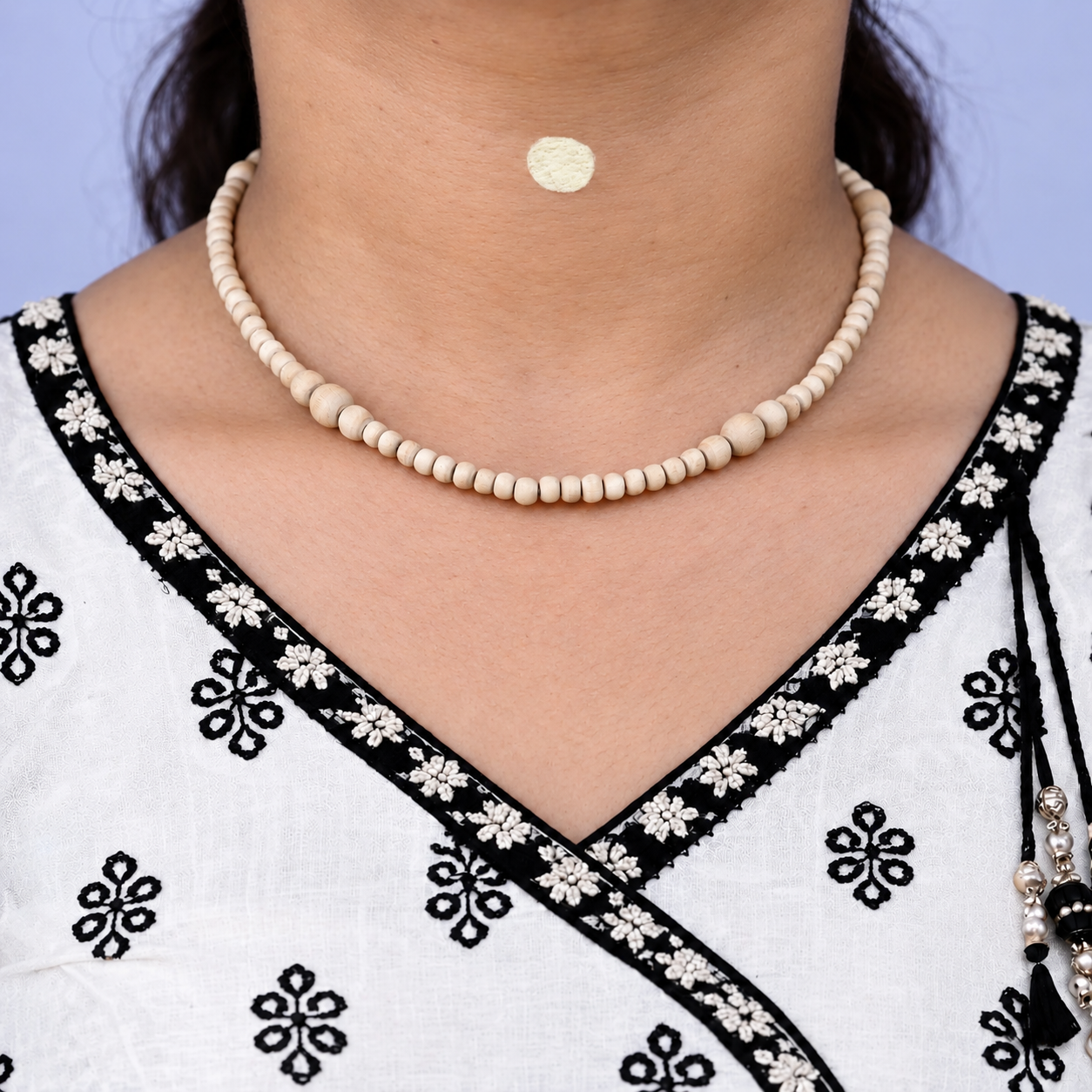 Tulsi kanthi mala with small wooden beads and larger round accents worn with a white and black embroidered kurta.
