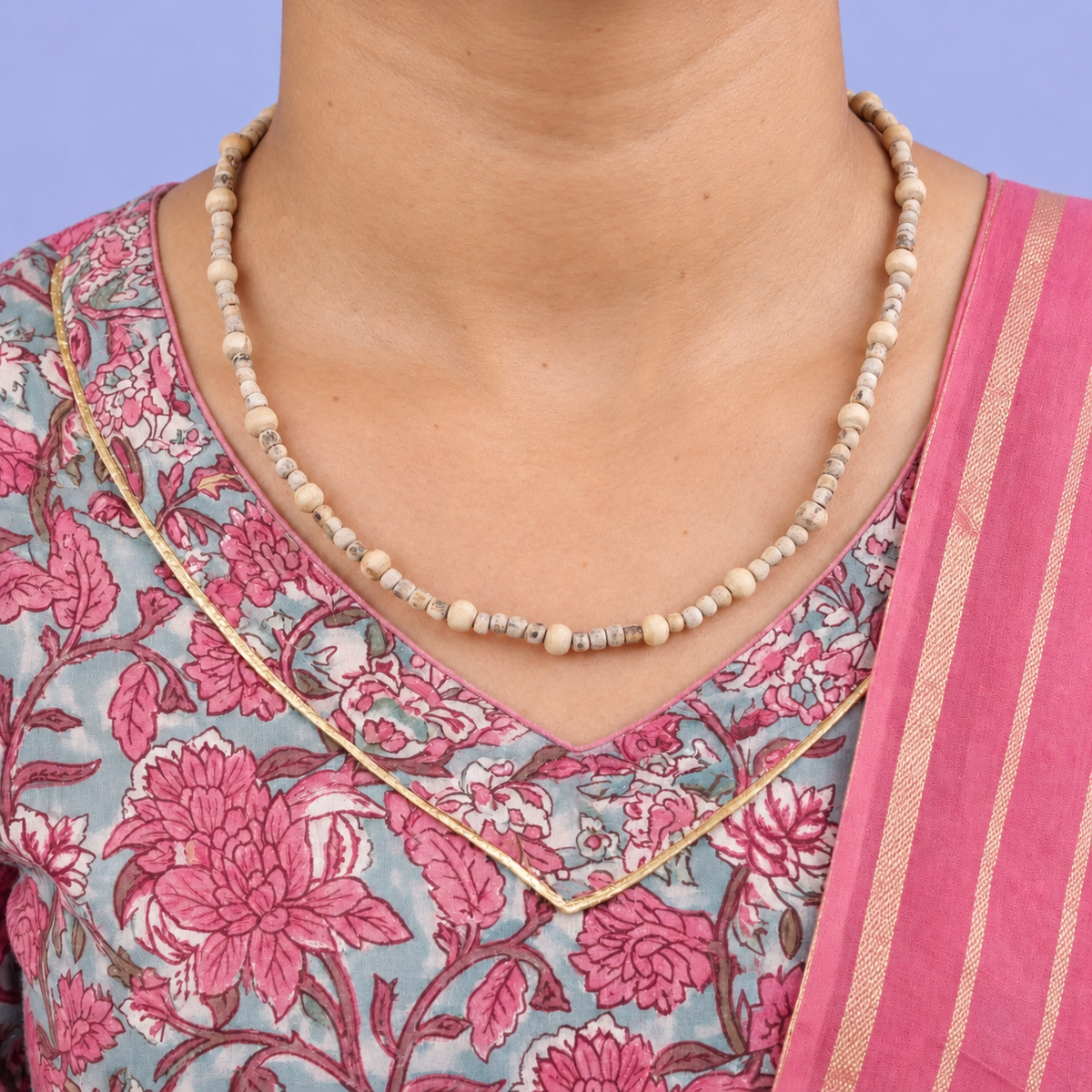 Tulsi kanthi mala with small wooden beads and larger round spacers worn with a pink floral outfit.