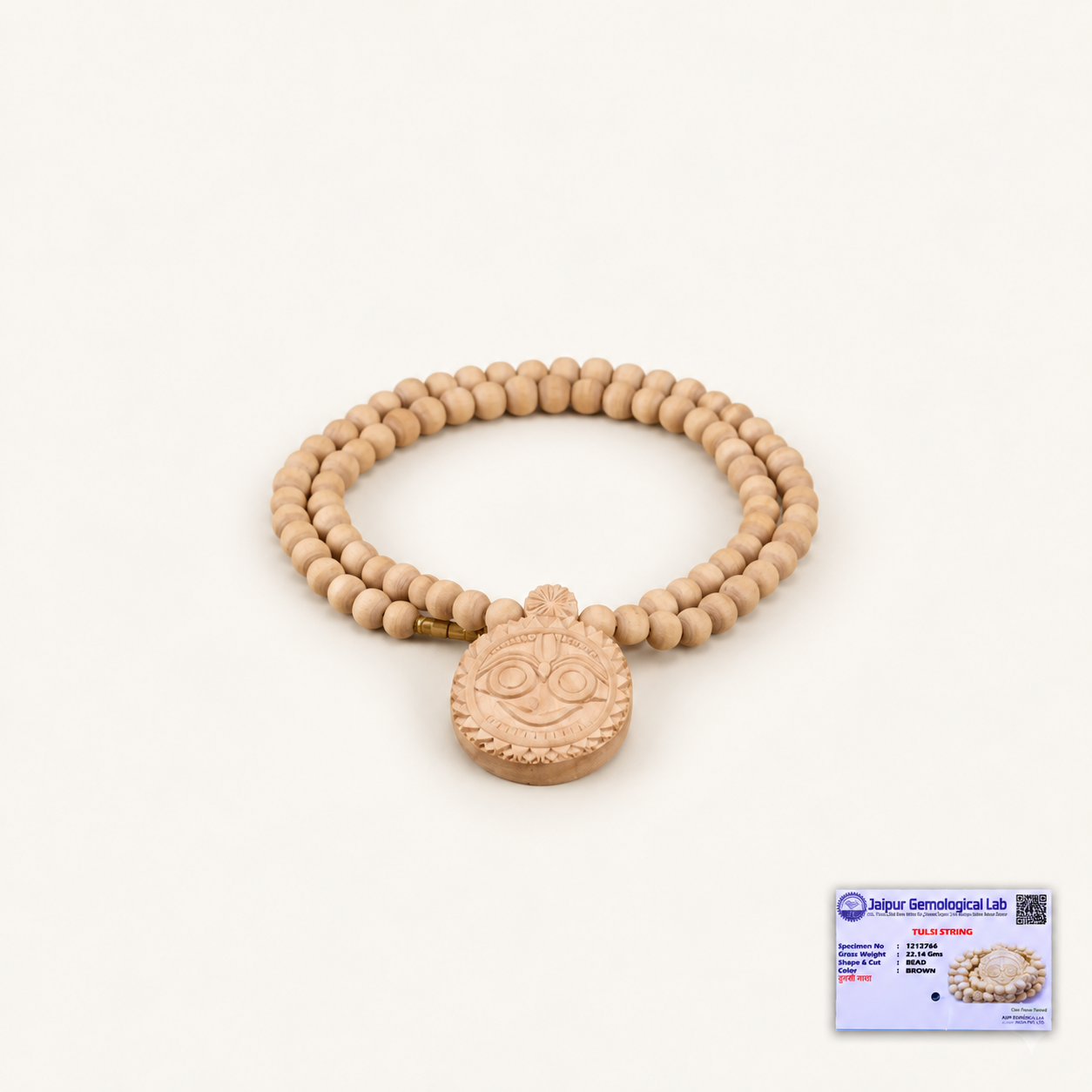 Off-white background par Tulsi bead mala aur carved Jagannath pendant, bottom right mein certificate ke saath.