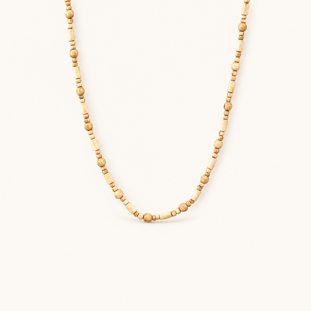 Tulsi mala with alternating round and cylindrical wooden beads on an off-white background.
