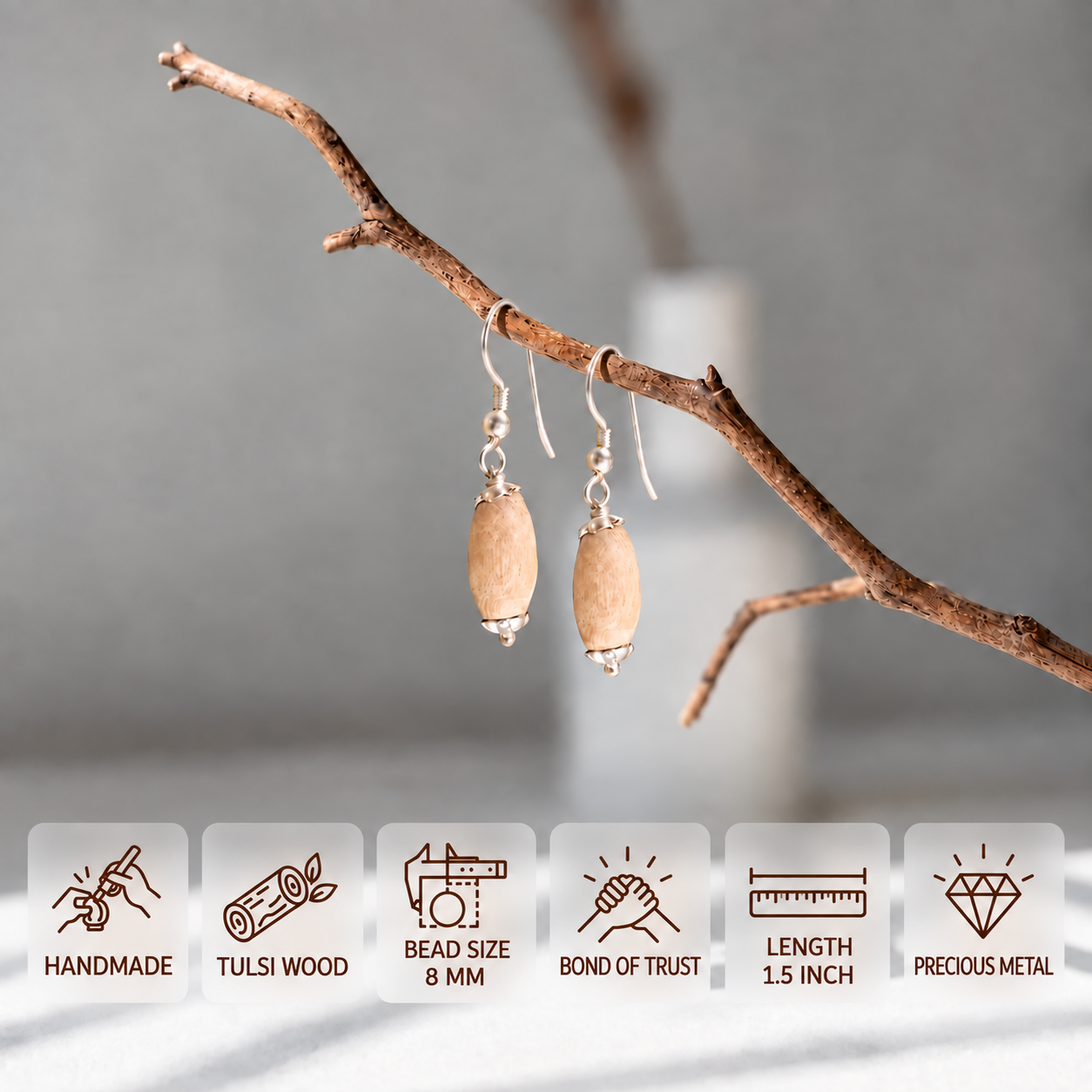 Pair of Tulsi wood drop earrings with silver-toned hooks hanging from a branch, showing 8 mm bead size and 1.5 inch length.