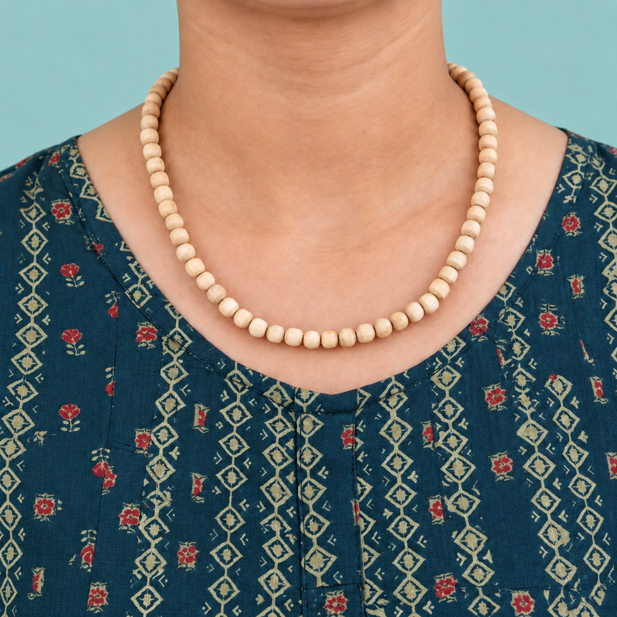 Tulsi kanthi mala with pale rounded wooden beads worn with a teal floral kurta.