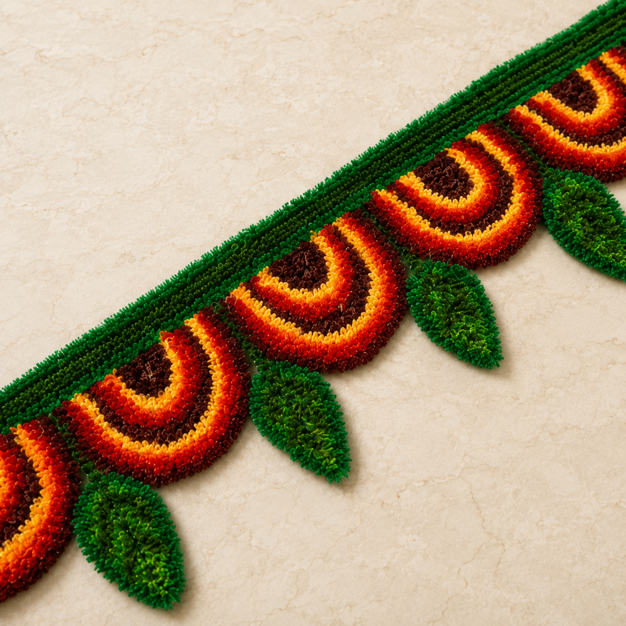 Colourful woolen rangoli toran with maroon, orange and green pattern for Diwali home decor